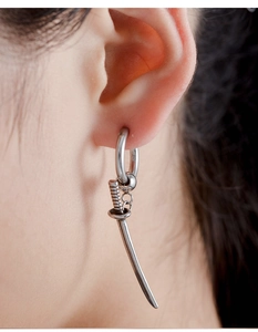 Close-up detail of a silver katana sword dangle earring on a male model with hip hop style