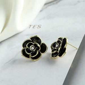 Elegant black enamel camellia stud earrings with gold trim and center crystal accent
