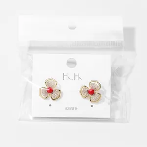 Elegante goldene Blumenohrringe mit Zirkonia-Pflasterung und roten Perlenmitten