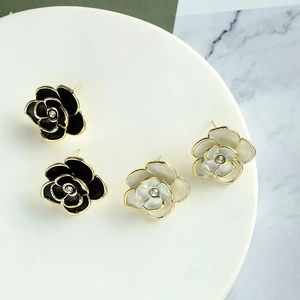 Elegant camellia flower stud earrings in black and cream enamel with gold edges