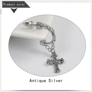 Detail view of antique silver hoop earring with double chains and a cross pendant