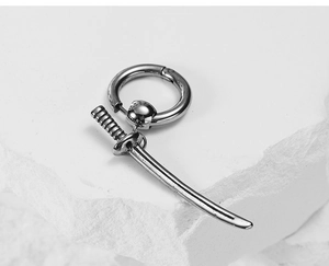 Detailed close-up of a silver stainless steel samurai sword pendant earring on stone