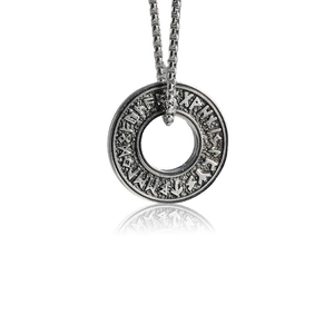 Détail de la gravure de runes vikings sur un pendentif circulaire creux en acier