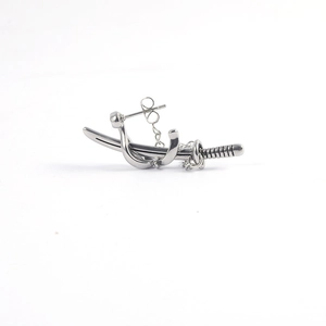 Detailed view of a silver sword-shaped earring with chain and textured hilt detail