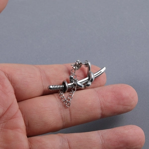 Macro shot of silver katana sword earring with chain detail in punk hip-hop style