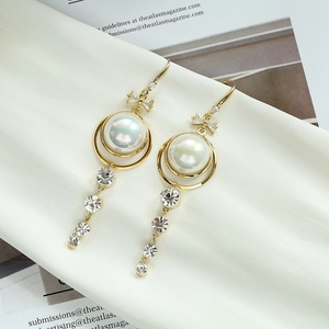 Élégantes boucles d'oreilles dorées avec perle irisée et accents de zircons brillants