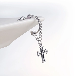 Polished stainless steel hoop earring with chain and cross pendant on white decor