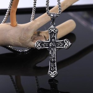 Macro shot of retro stainless steel cross pendant with Virgin Mary relief on wood
