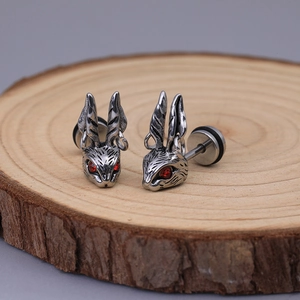 Boucles d'oreilles lapin rétro en acier avec yeux rouges sur tranche de bois brut