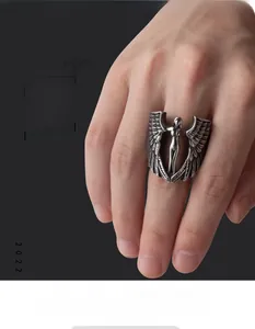 Close-up of vintage silver angel wings ring with detailed feather texture on model finger