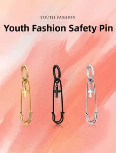 Three safety pin drop earrings with small cross charms in gold, matte black, and silver