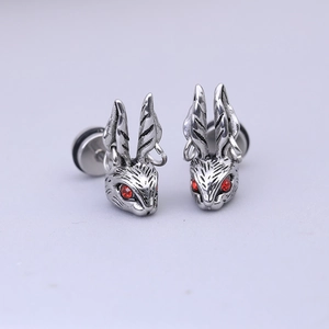 Vue macro de boucles d'oreilles lapin en argent avec yeux rouges et détails punk