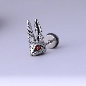 Détail d'une boucle d'oreille lapin en acier inoxydable vintage avec des yeux rouges