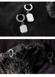 Detail of square geometric drop earrings in polished steel and black enamel finish