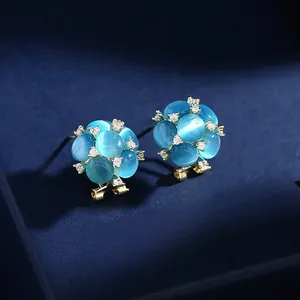 Primo piano dei dettagli degli orecchini a fiore con occhio di gatto blu in scatola regalo