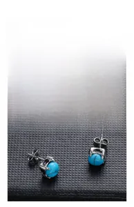 Macro shot of punk style rose claw earrings with bright blue turquoise center stone