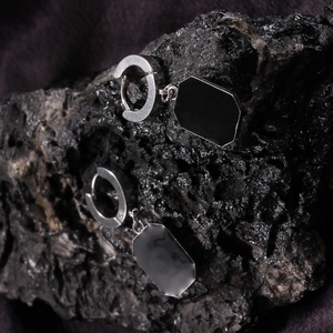 Minimalist square geometric earrings in polished stainless steel on volcanic rock