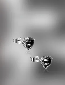 Macro detail of gothic dragon claw earrings with faceted black stones in silver setting