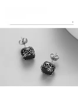 Gros plan sur boucles d'oreilles en acier titane vintage avec gemmes noires ciselées
