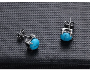 Detailed close-up of punk style stainless steel earrings with blue marble stones