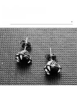 Detailed macro view of vintage dragon claw stud earrings holding black stones