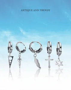 Lot de cinq boucles d'oreilles créoles en acier avec pendentifs croix et épée