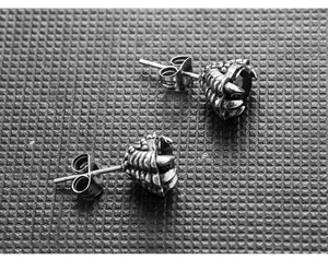 Detailed close-up of gothic stainless steel dragon claw earrings with black stone