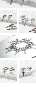 Détail de boucles d'oreilles punk argentées avec pendentifs croix, plume et étoile