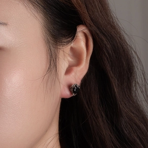 Minimalist stainless steel eagle claw stud earrings with a black oval gemstone