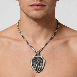 Close-up of a men's vintage silver shield necklace with detailed Spartan warrior relief