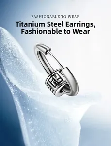 Macro shot of silver stainless steel earring with vertical cross and engraved pattern