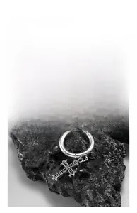Macro view of vintage silver stainless steel cross earrings on black mineral stone