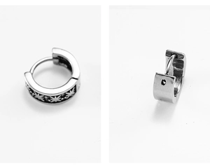 Detailed macro view of vintage square stainless steel earrings with engraved sunburst patterns