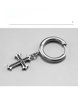 Detailed view of silver stainless steel cross earring with vintage textured finish and small stone