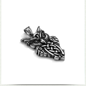 Detailed macro view of vintage stainless steel owl pendant with Celtic knot pattern