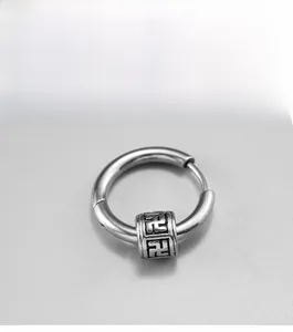 Detail of silver stainless steel hoop earring with engraved spiritual cylinder bead