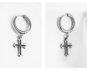 Detailed macro view of stainless steel cross earrings with vintage textured finish