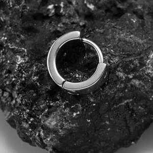 Minimalist square stainless steel hoop earrings for men on black volcanic rock background