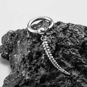 Silver punk style cross ear cuff with articulated spinal drop on volcanic stone