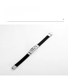 Détail macro du bracelet homme en silicone noir avec relief de dragon argenté