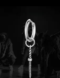 Detail of silver titanium steel sword earring with textured weaving pattern in hip hop style