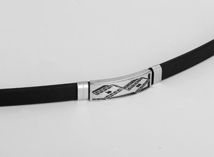 Dettaglio di bracciale da uomo in silicone nero con motivo a meandro inciso su metallo