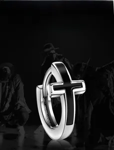 Close-up of silver stainless steel cross hoop earring with black enamel hip-hop design