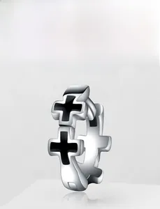 Macro shot of stainless steel hoop earrings with black double cross motifs and reflection
