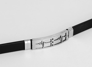 Macro detail of men's silicone bracelet showing ECG pattern on stainless steel plate