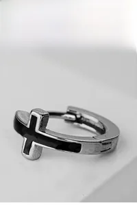 Macro view of silver stainless steel hoop earrings with an inlaid black cross detail