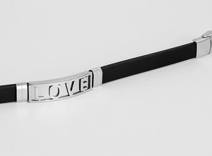 Makroaufnahme von schwarzem Silikonarmband mit silberner LOVE-Plakette und Metallverschluss