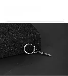 Detail of punk style stainless steel hoop earring with vintage sword pendant
