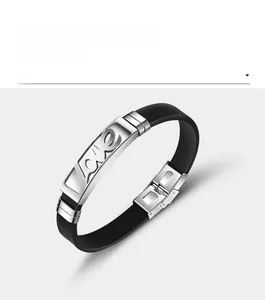 Dettaglio del bracciale in silicone nero con ciondolo 'Love' in acciaio traforato e chiusura