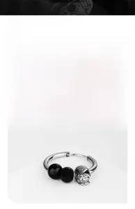 Détail de la boucle d'oreille punk tête de mort avec perles noires et anneau en acier
